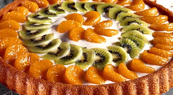 En vacker frukttårta med mandarinklyftor och kiwiskivor som dekoration. Ett perfekt frukttårta recept för sommaren!