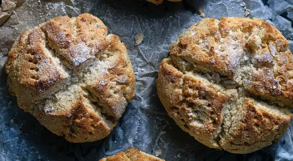 Nybakade scones med kvarg, gyllene och inbjudande, strösslade med lite mjöl. Perfekta för en mysig fika.