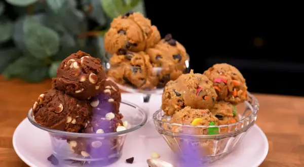Tre skålar med olika sorters cookie dough recept: choklad med vita chokladknappar, klassisk med chokladknappar och färgglad med godisbitar.