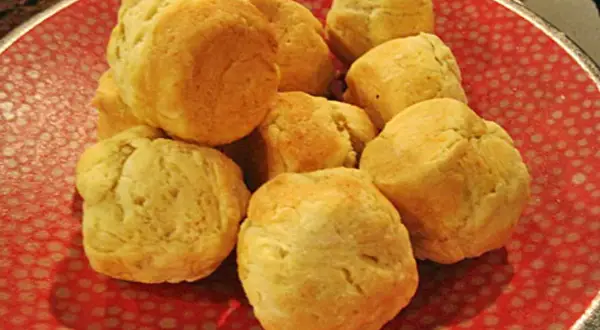 En hög med fluffiga scones i muffinsform på en röd tallrik med prickar. Perfekt för fika!