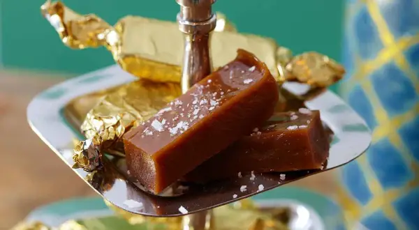 Två bitar salt karamell, perfekt julgodis med lakritssmak, på ett silverfat.