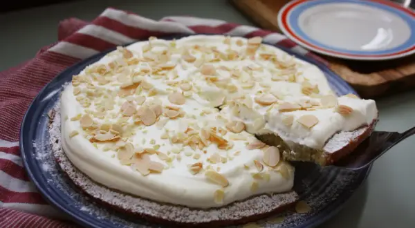 En saftig semmelkladdkaka med fluffig grädde och mandelmassa, toppad med mandelspån. En dröm för alla fikasugna!