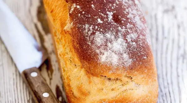 Nybakad limpa med knaprig skorpa, redo att skivas. Ett enkelt limpa recept för hembakat bröd.
