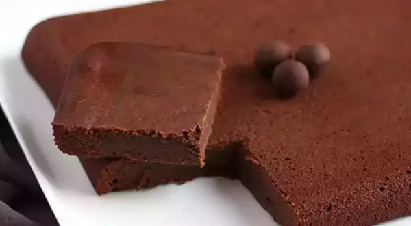 En fudgig chokladkaka, perfekt istället för smör i bakning. Tre chokladkulor ligger på ytan.
