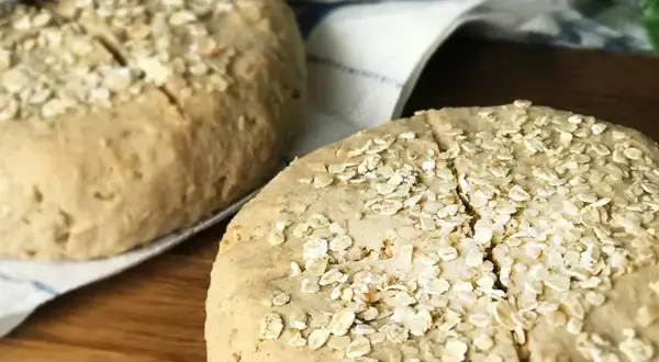 Två hembakta scones med bovetemjöl och havregryn på en kökshandduk.