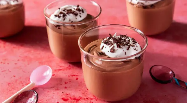 Chokladmousse recept: Krämig chokladmousse i glas, toppad med vispad grädde och chokladspån. Perfekt för en lyxig dessert.