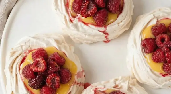 Små marängbottnar fyllda med krämig lemoncurd och toppade med färska hallon och jordgubbar. En härlig pavlova!