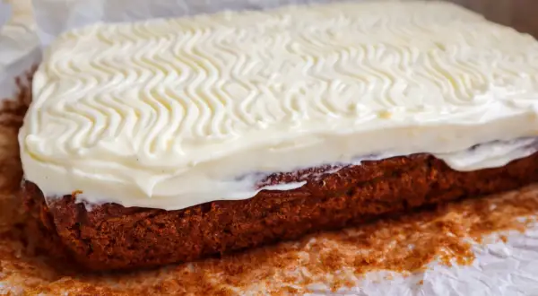 En saftig glutenfri morotskaka med krämig frosting, perfekt för fika.
