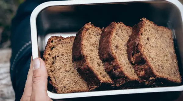Skivor av saftig banankaka i en metallbehållare, perfekt för utflykten. Ett enkelt banankaka recept som passar alla.