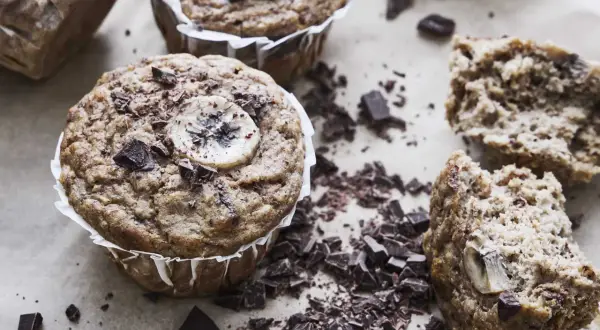 Nyttiga bananmuffins med chokladbitar och bananskivor, perfekta för fika.