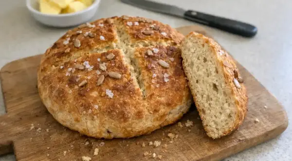 Nybakad, gyllene brödlimpa med solrosfrön och flingsalt, perfekt för frukost eller fika. Detta bröd är bakat utan jäsmedel.