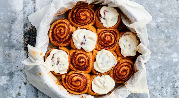 Nybakade kanelbullar med krämig glasyr, redo att jäsa deg till perfektion.