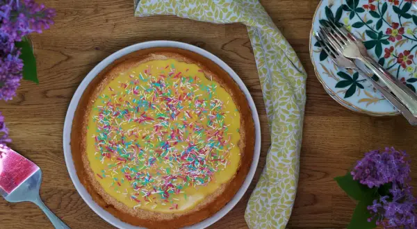 En härlig silviakaka med gul glasyr och färgglatt strössel, redo att avnjutas. Ett perfekt silviakaka recept för fikastunden.