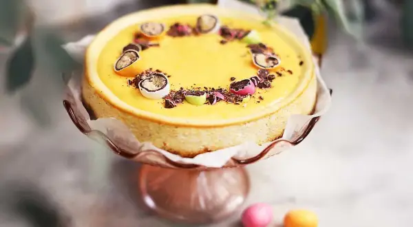 En gul cheesecake med påskpynt, choklad och små ägg. En perfekt cheesecake påsk-dessert.
