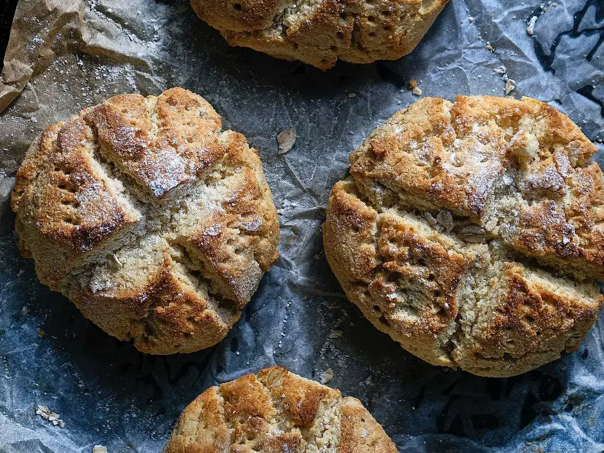 Nybakade scones med kvarg, gyllene och inbjudande, strösslade med lite mjöl. Perfekta för en mysig fika.