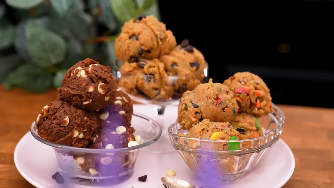 Tre skålar med olika sorters cookie dough recept: choklad med vita chokladknappar, klassisk med chokladknappar och färgglad med godisbitar.