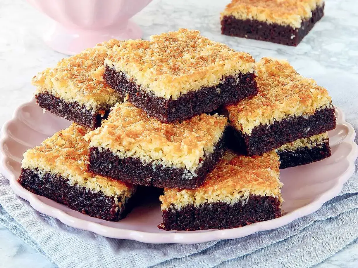 Enkla bakverk med chokladbotten och kokostäcke på en rosa tallrik. Perfekt för fikat!