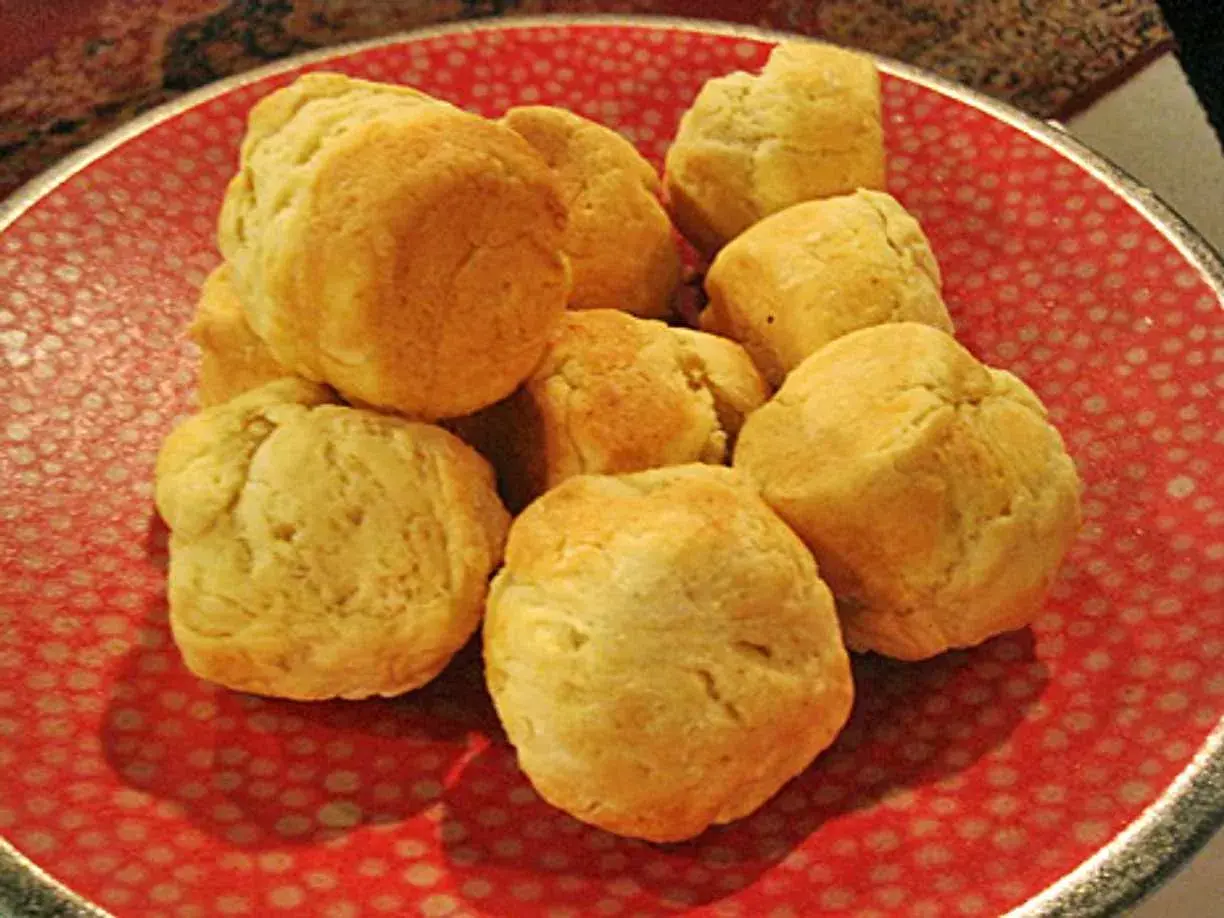 En hög med fluffiga scones i muffinsform på en röd tallrik med prickar. Perfekt för fika!