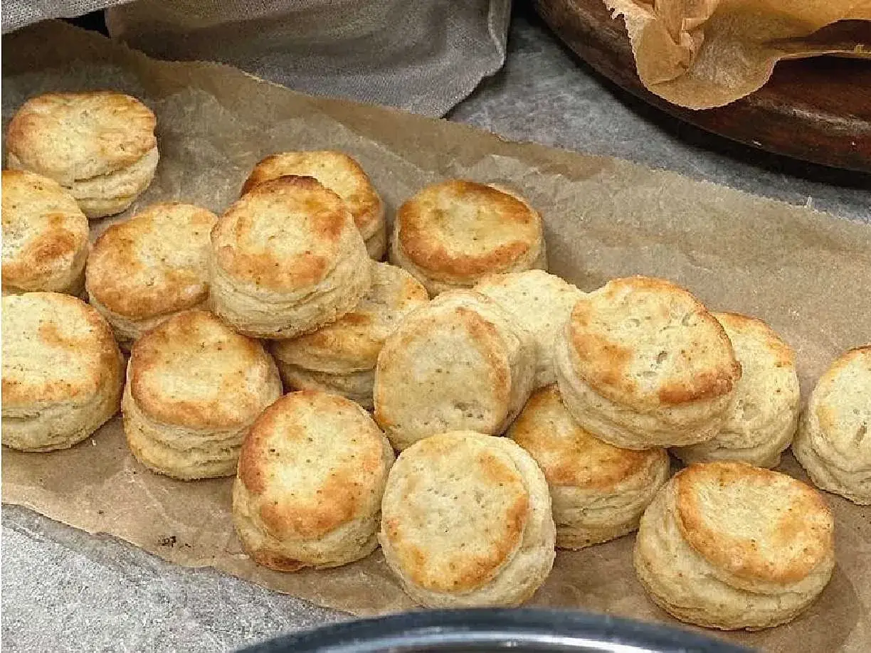 En hög med små scones, gyllene och fluffiga, redo att avnjutas. Perfekta till fikat!