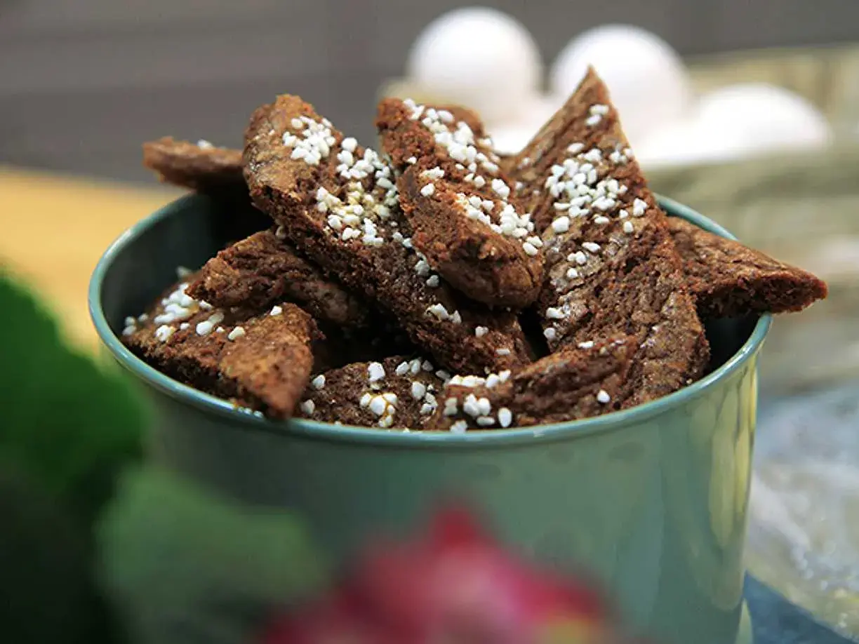 Chokladsnittar recept: Mörka, trekantiga småkakor med pärlsocker i en grön skål. Perfekt för fikat!