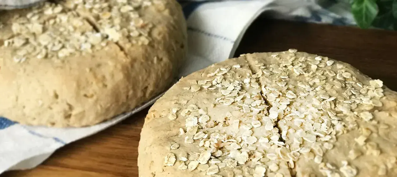 Två hembakta scones med bovetemjöl och havregryn på en kökshandduk.