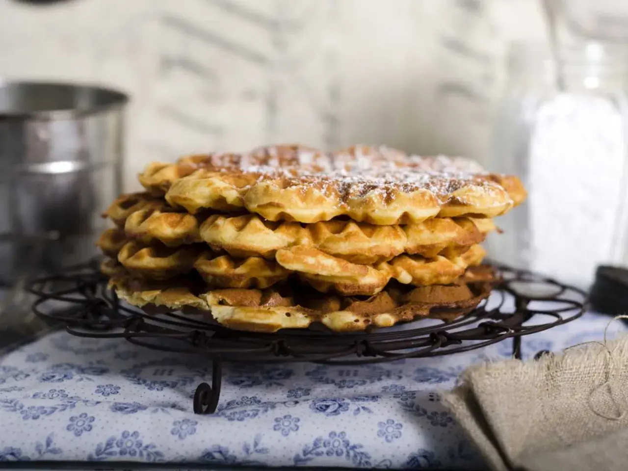En hög med nybakade, pudrade våfflor som väntar på att serveras. Perfekt för en mysig fika.