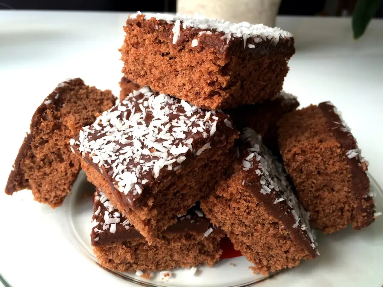En hög med saftiga mockarutor glutenfria, toppade med chokladglasyr och kokosflingor. Perfekt för fikat!