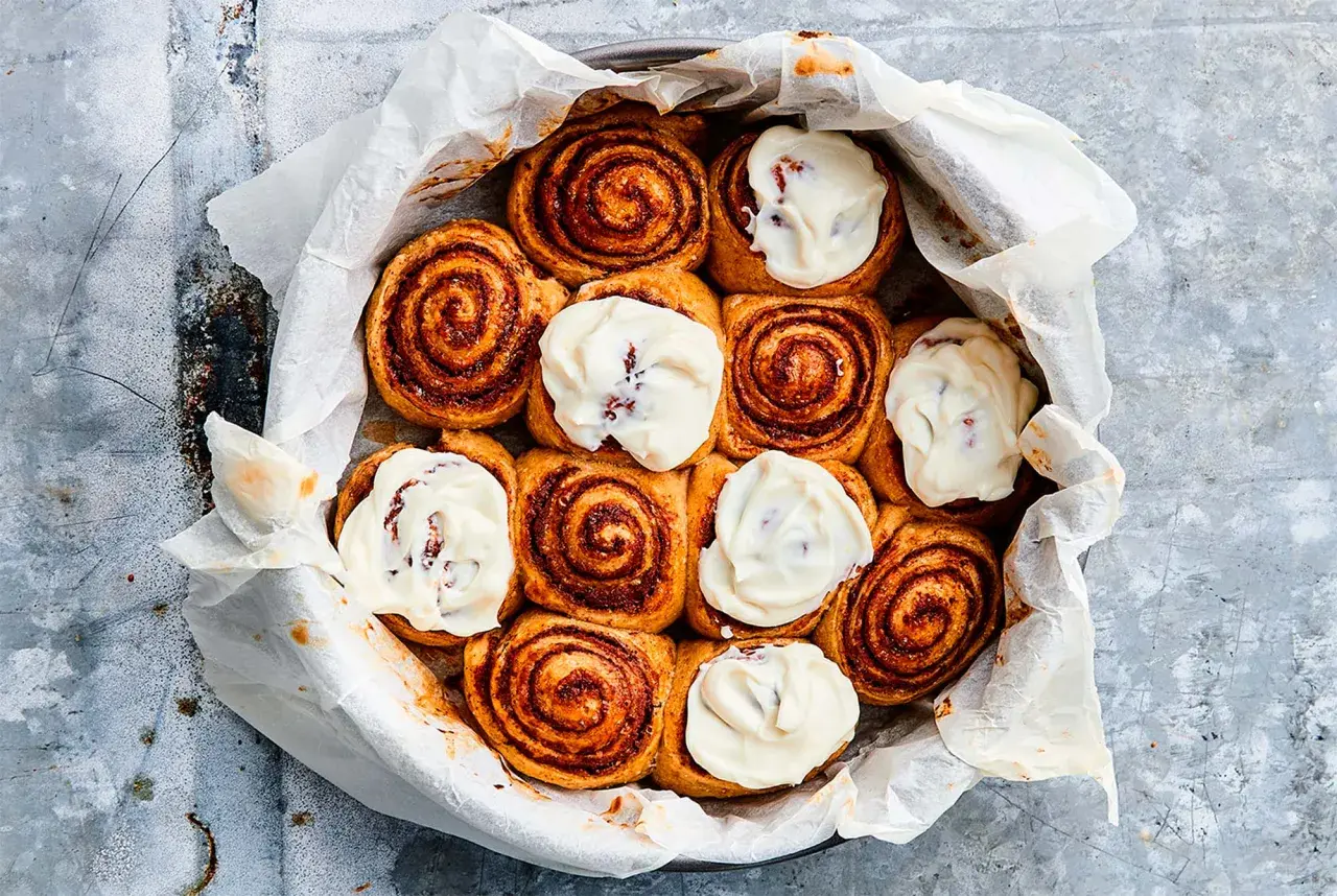 Nybakade kanelbullar med krämig glasyr, redo att jäsa deg till perfektion.