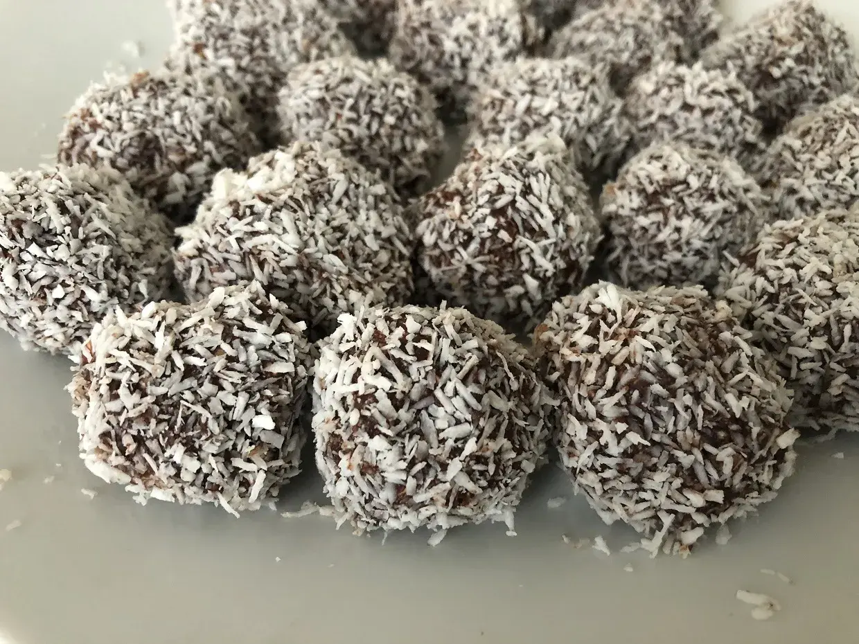 En hög med chokladbollar, perfekta för ett enkelt chokladbollar recept. De är rullade i kokosflingor.