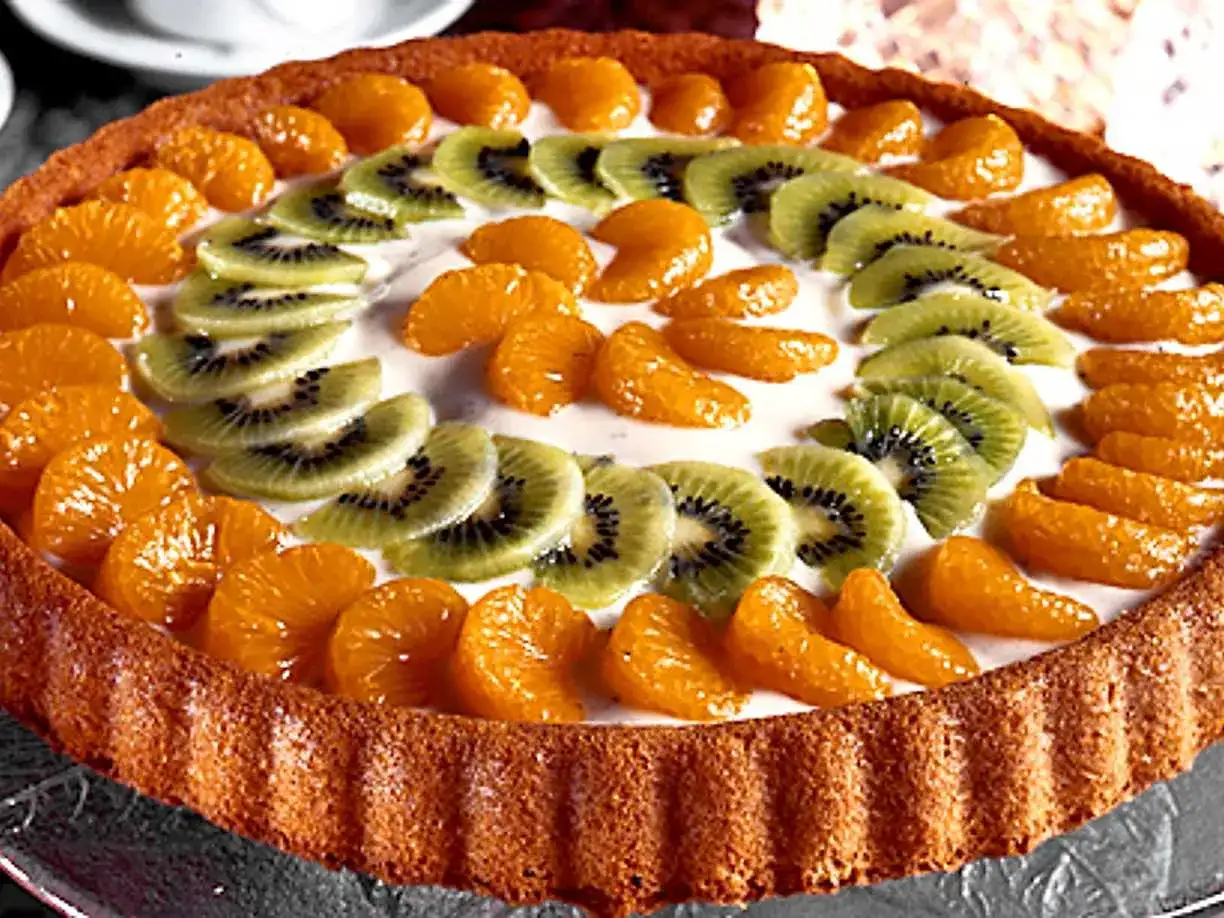 En vacker frukttårta med mandarinklyftor och kiwiskivor som dekoration. Ett perfekt frukttårta recept för sommaren!