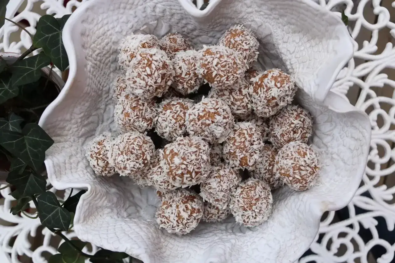 En sk&aring;l med hemgjorda havrebollar, rullade i kokosflingor. Perfekt f&ouml;r ett enkelt havrebollar recept.