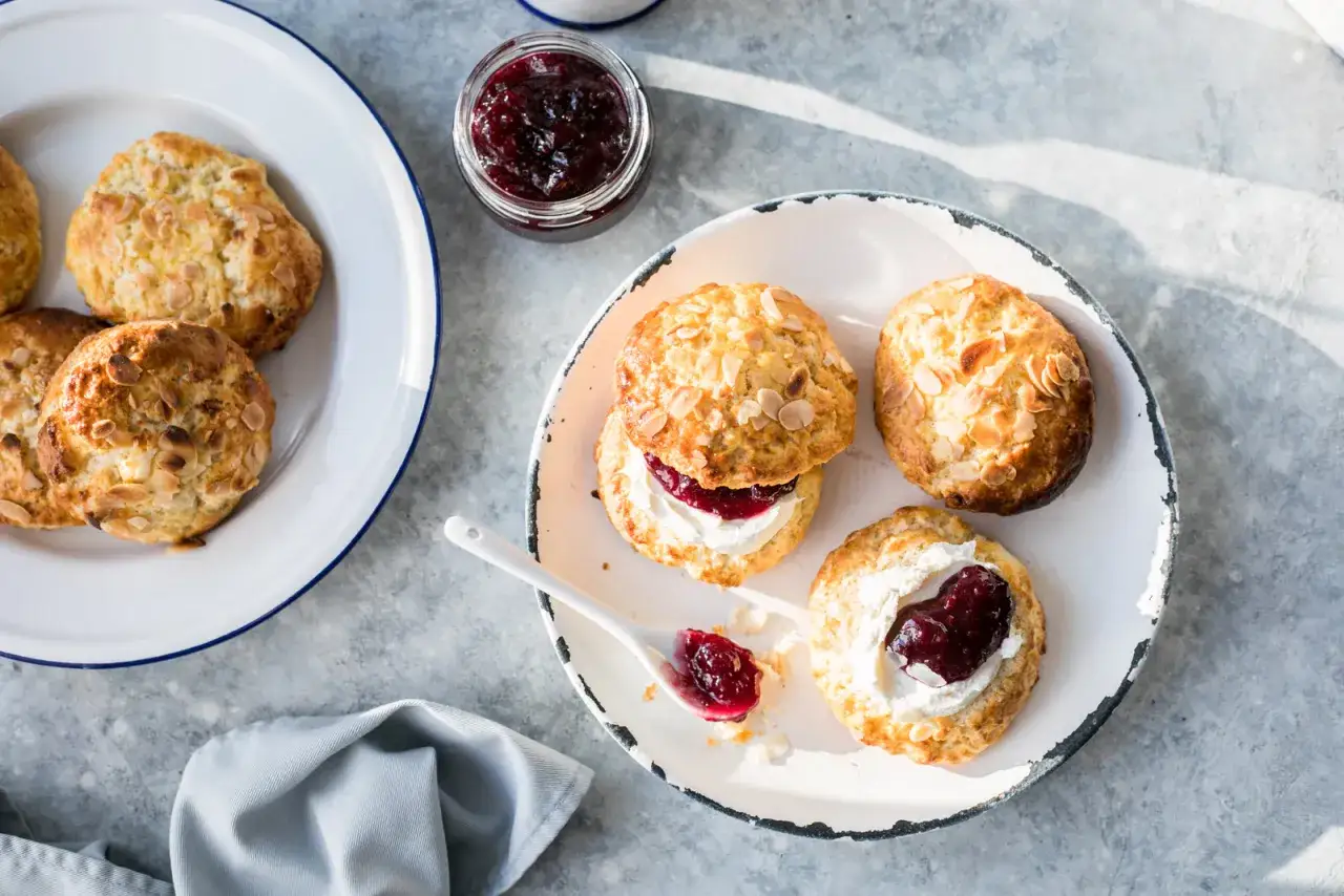 Scones med mandelflagor, grädde och sylt. Bra att veta att man kan frysa scones för framtida fikastunder.