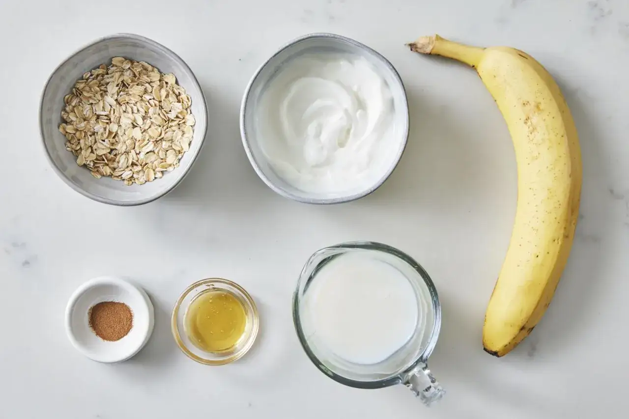 Ingredienser för ett krämigt smoothie recept: havregryn, yoghurt, banan, kanel, honung och mjölk.