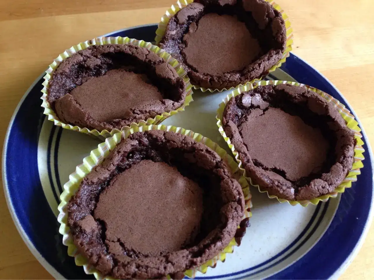 Fyra chokladmuffins i gula pappersformar på en tallrik. Perfekt för dig som vill baka istället för smör i bakning.