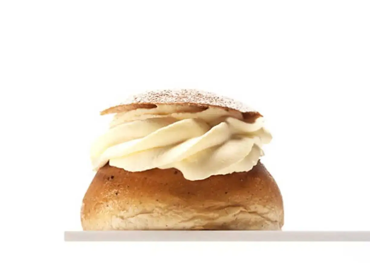 En semla med rikligt med grädde och mandelmassa till semlor, pudrad med florsocker.