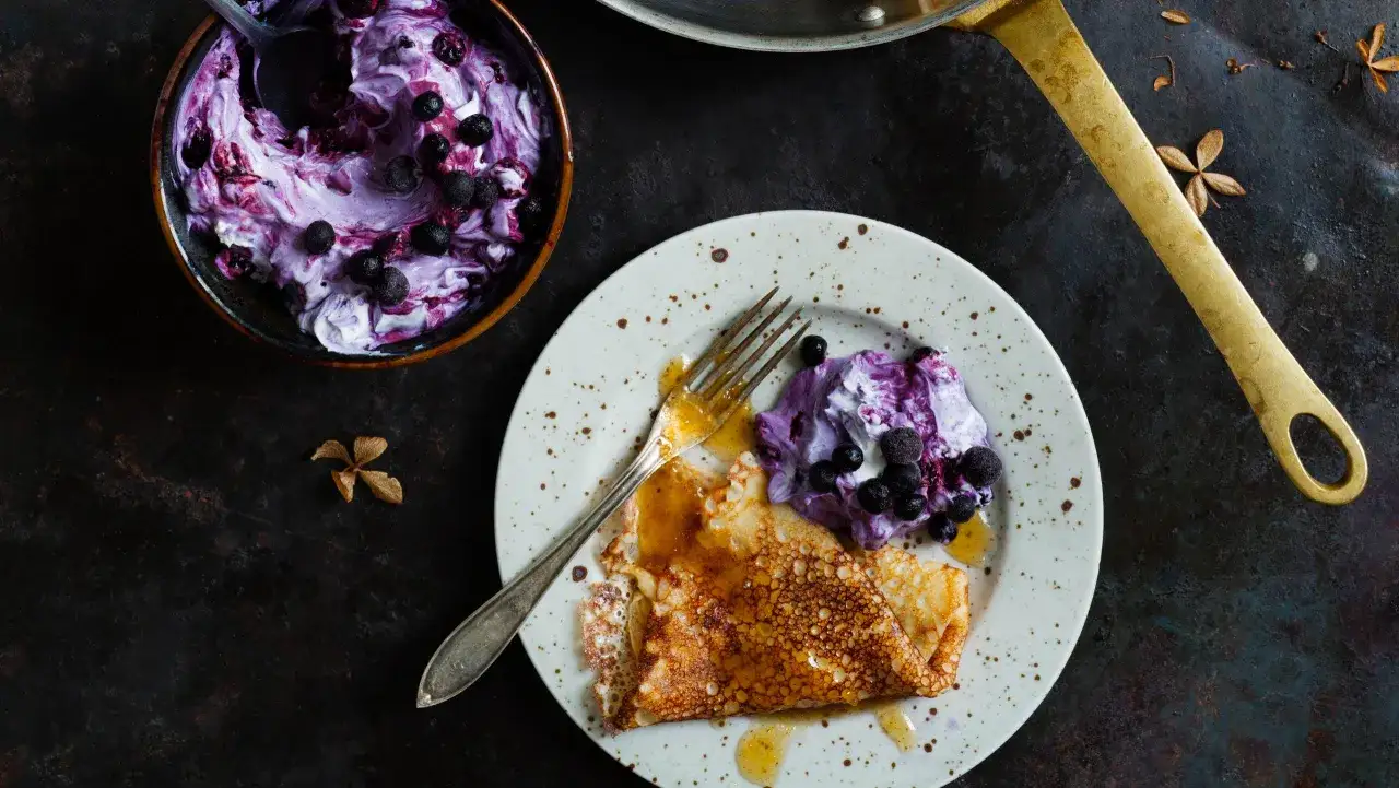 En perfekt pannkaka med blåbärssås och grädde, redo att avnjutas. Ett enkelt crepes recept för alla.