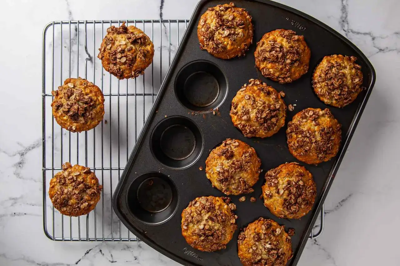 Nyttiga bananmuffins med havregryn och kanel toppas med en krispig granola. Perfekta för frukost eller mellanmål.