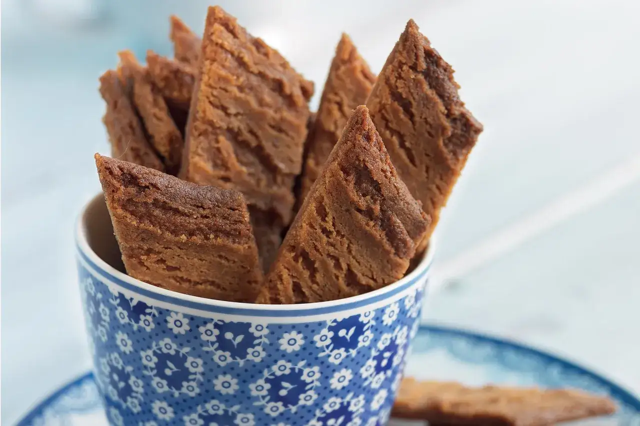 En blåvit mönstrad kopp fylld med gyllenbruna, spröda kolakakor utan bakpulver. Perfekta att doppa i kaffet.
