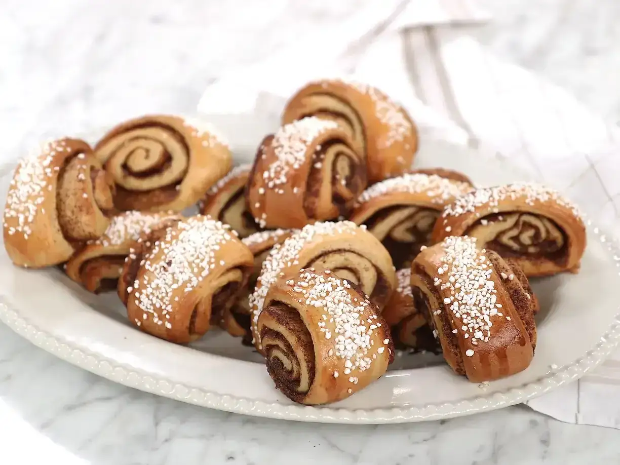 En tallrik med nybakade gifflar, perfekta f&ouml;r fikat. Dessa kanelbullar ser ut som ett underbart gifflar recept.