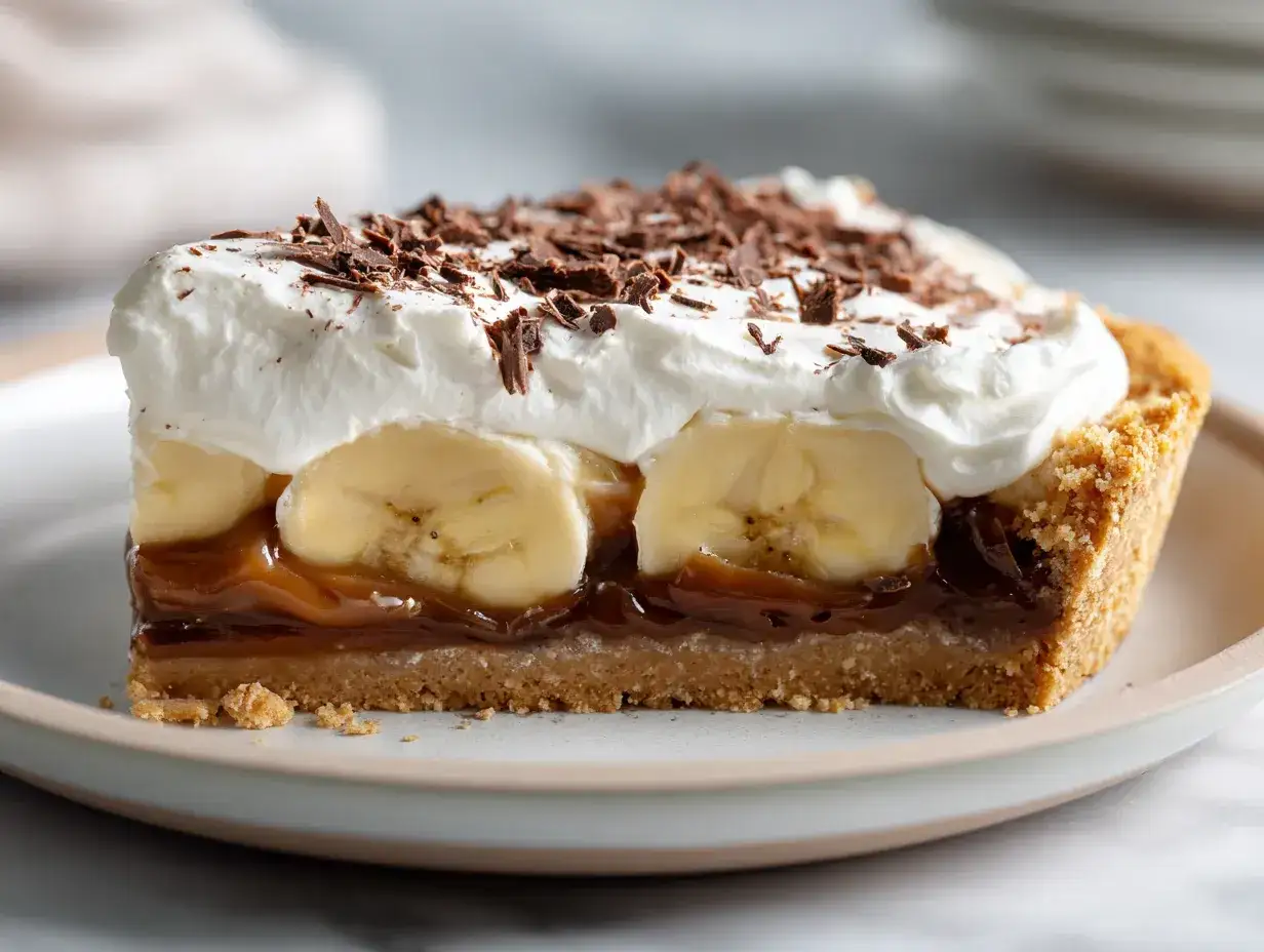 En bit kolapaj dulce de leche med banan, vispgrädde och chokladströssel.