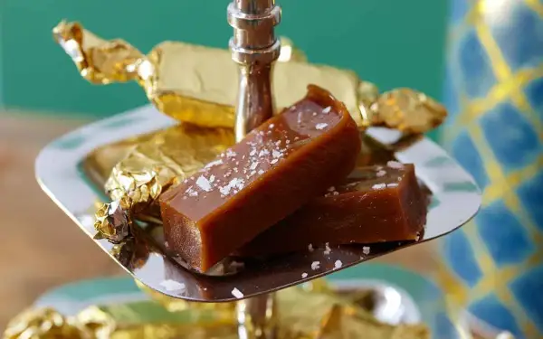 Två bitar salt karamell, perfekt julgodis med lakritssmak, på ett silverfat.