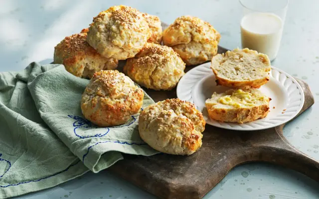 Snabba bullar med sesamfrön, perfekta till frukost eller fika. En halv bulle med smör ligger på en tallrik bredvid.