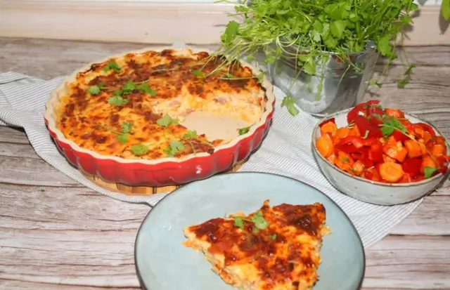 En gyllene paj utan pajdeg, fylld med godsaker och toppad med örter. Serveras med en fräsch sallad av paprika och morötter.